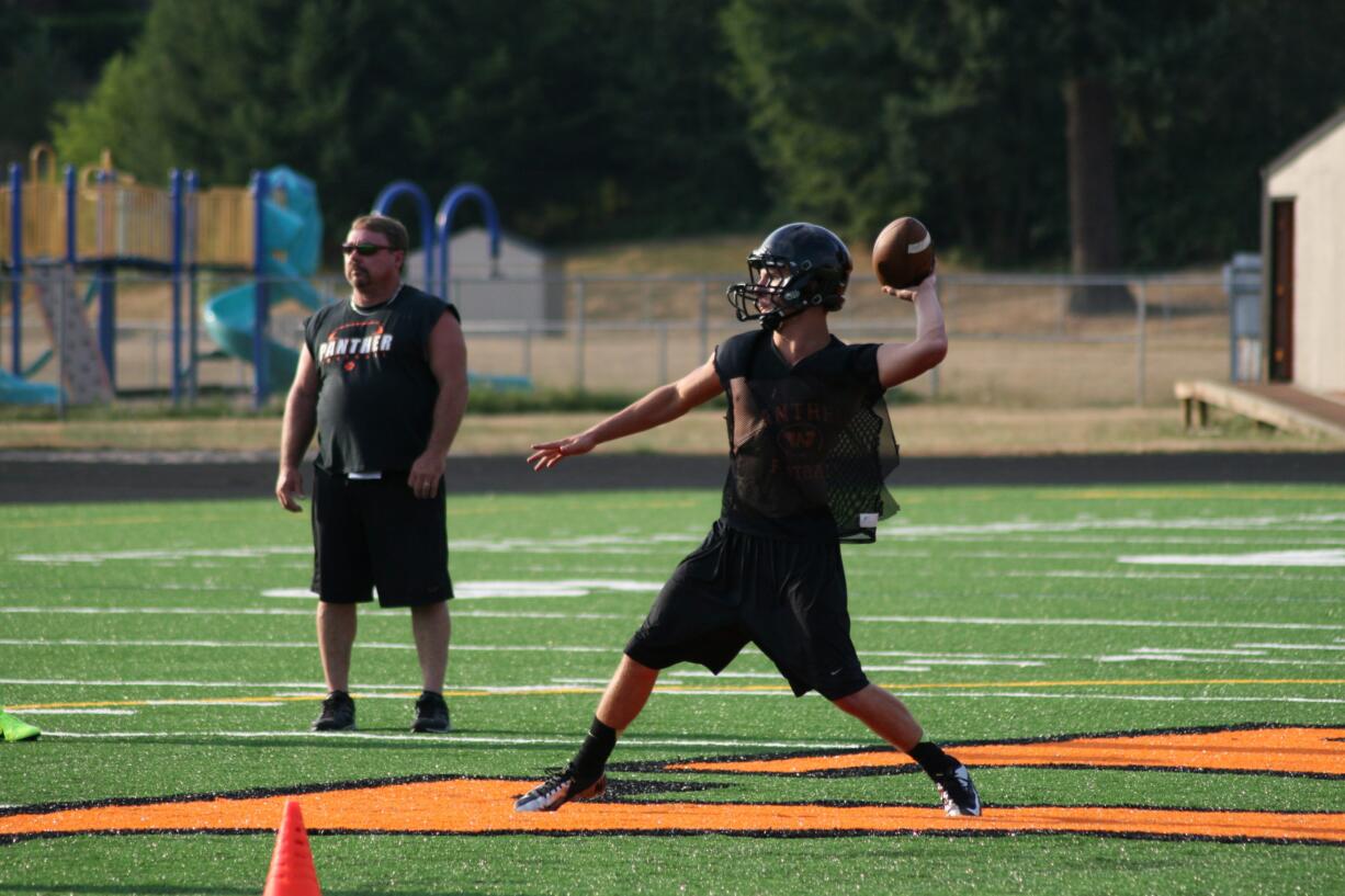 Quarterback Chase Duey delivers a pass from the orange Washougal &quot;W.&quot; The Panthers play their first football game on the new turf at Fishback Stadium Friday, Sept. 6.