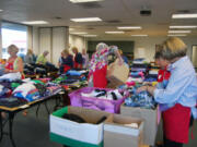 Volunteers with the Assistance League of Southwest Washington work briskly to set up for the &quot;Teen Day&quot; at the Department of Health and Human Services in Vancouver last week. On Thursday, children in foster care were able to attend the event and select two complete outfits in preparation for the start of the new school year.