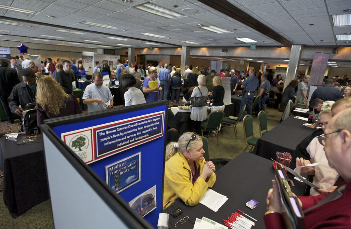 Maggie Lund, a customer service specialist for the Human Services Council, talks to people interested in working for the council at a job fair hosted by Rep. Jamie Herrera Beutler at the Red Lion at the Quay on June 10.