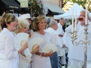 More than 150 people attended the &quot;Camas in White, Dinner on Fourth Avenue&quot; event on Saturday evening in downtown. Attendees dressed in white outfits and dined at tables decorated in white color themes. This group of friends, many of whom are neighbors in the Lacamas Shores area, pose for pictures before dinner begins. The event was a fundraiser for the Camas-Washougal Mural Project. Through an auction of five art pieces, approximately $2,215 was raised, including a $1,400 winning bid by Capstone Technology Corp. for a  painting of the Camas mill by local artist Maria Grazia Repetto.