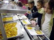 A student adds some French fries to her lunch tray. New U.S.