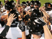 The Washougal High School football players celebrate with head coach Bob Jacobs after beating Hudson's Bay 50-0 Friday night, at Kiggins Bowl in Vancouver.