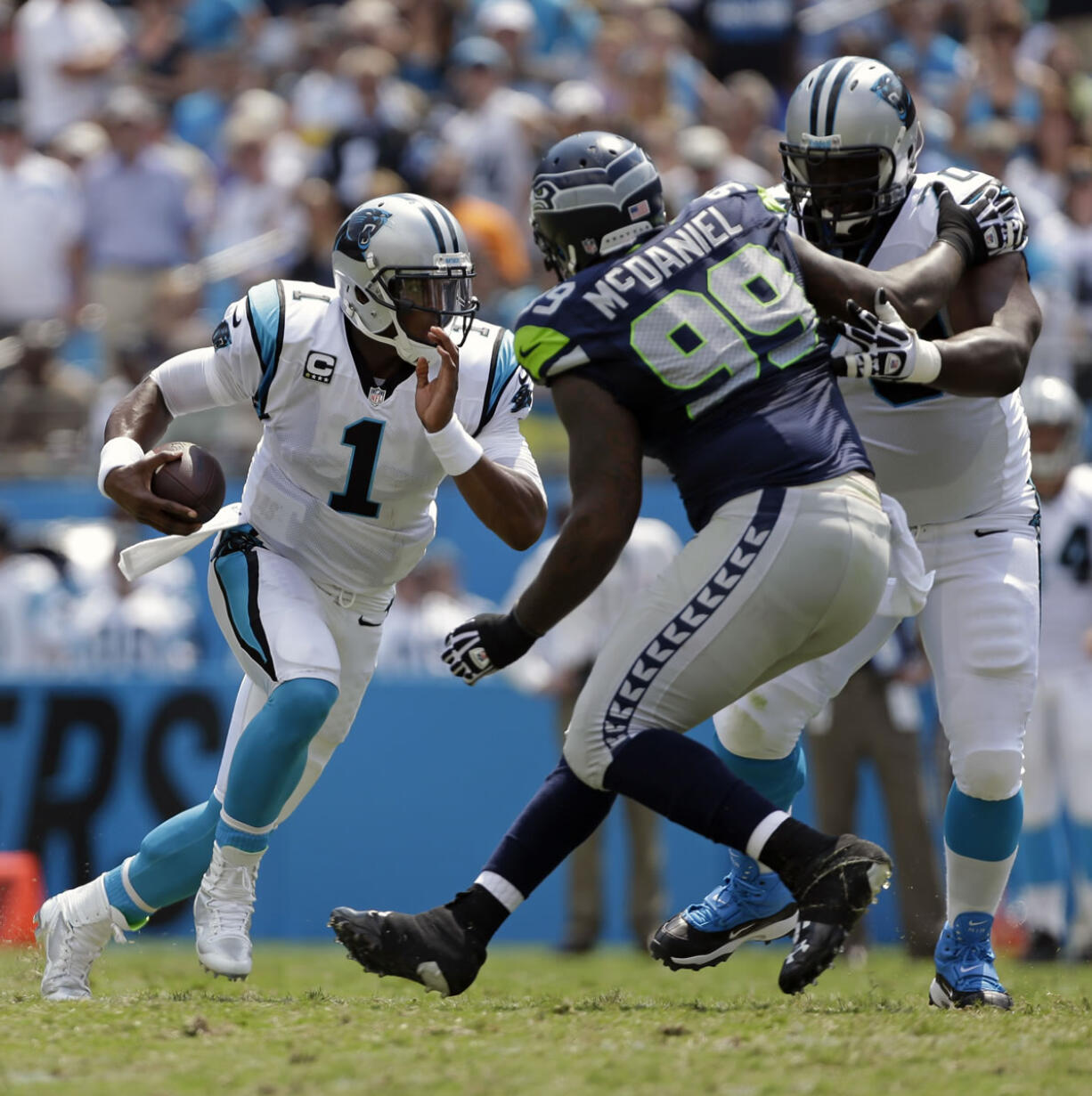 Seahawks defensive tackle Tony McDaniel (99) works to get around Carolina's Edmund Kugbila to get at quarterback Cam Newton.