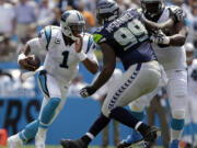 Seahawks defensive tackle Tony McDaniel (99) works to get around Carolina's Edmund Kugbila to get at quarterback Cam Newton.