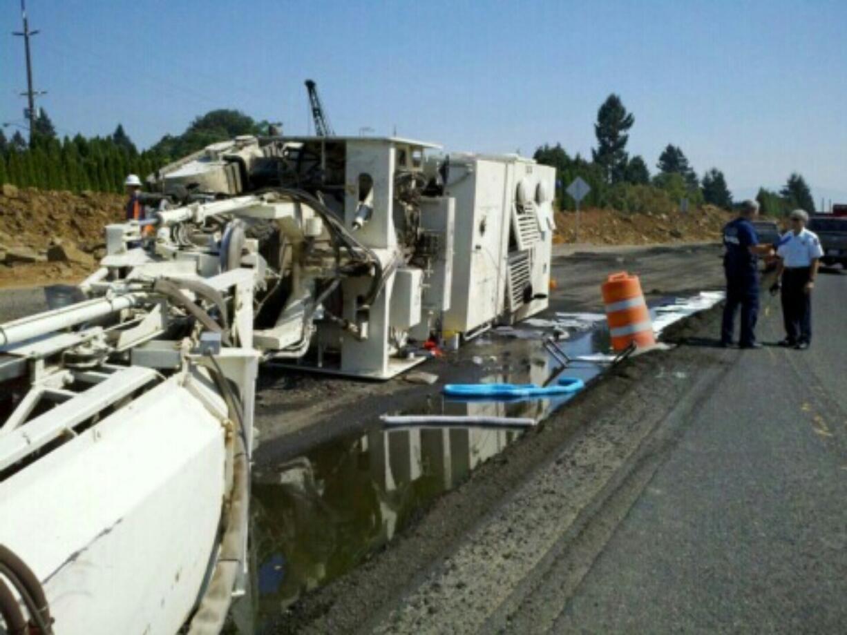 An asphalt grinder lies on its side on state Highway 14 in Washougal on Friday afternoon.