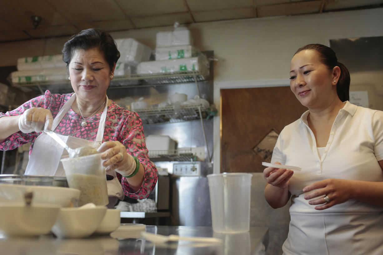 Thanh Tran, left, matriarch of the family that founded the popular Four Sisters restaurant in Falls Church, Va., demonstrates how to make Song Que's Bananas With Tapioca Pearls, aided by daughter Lieu Lai.