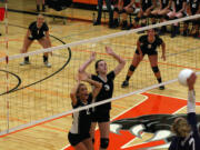 Washougal volleyball players Paige Bentley (2) and Carly Morris (3) reach up to protect the net. The Panthers played on their new floor for the first time Sept. 10.