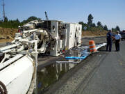 A pavement grinder tipped over earlier this afternoon on state Route 14 in Washougal, blocking the roadway in both directions.