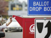 A voter slides a ballot into the drop box in downtown Vancouver in 2012.