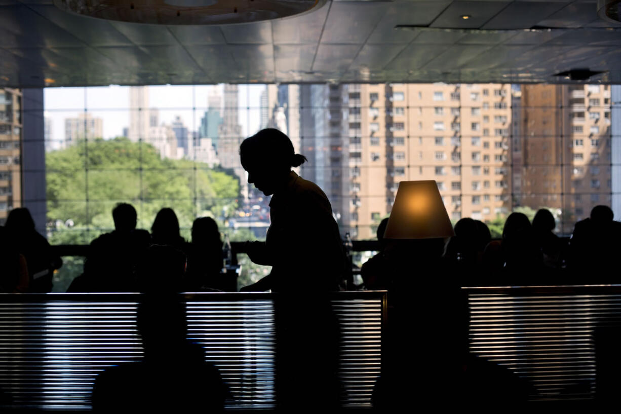 A waitress serves customers in New York.