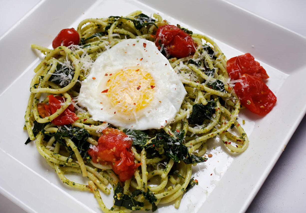 With a sunny-side egg on top, Spaghetti with Greens and Pistachio Pesto is a rich and hearty dish.