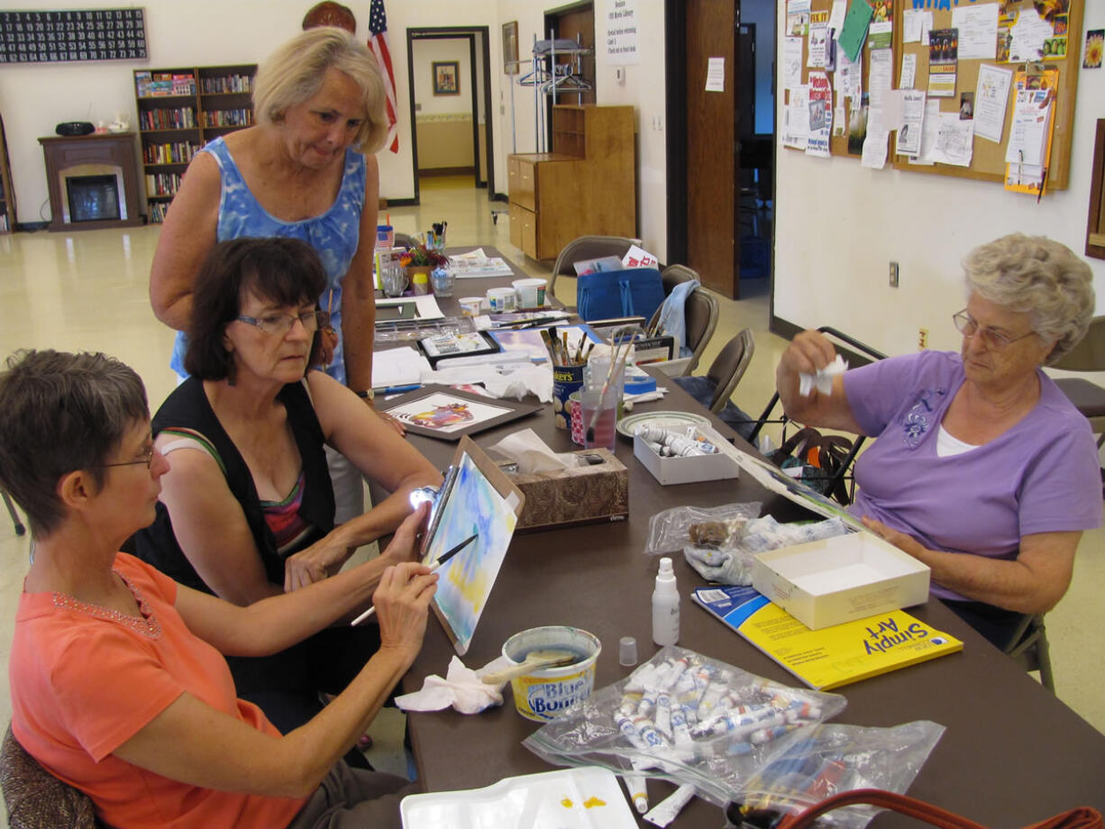 Dawn Feldhaus/Post-Record
Jan Wyninger shows her most recent painting to instructor Nancy Ryan and Barbara McHenry, as Dolly Jendro works on her own artwork at the Washougal Community Center. The Washougal Watercolorists will host an opening reception Friday, from 5 to 8 p.m. &quot;The purpose of the show is to share with the community the joy of watercolor and to complete the process of creation,&quot; Ryan said. &quot;Part of creation is having others appreciate and enjoy it.&quot;