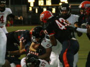 Camas High School offensive linemen Drew Clarkson, Troy Patterson and Jason Vailea part the waters, and Nate Beasley dives into the end zone to score the first of his four touchdowns for Papermakers.