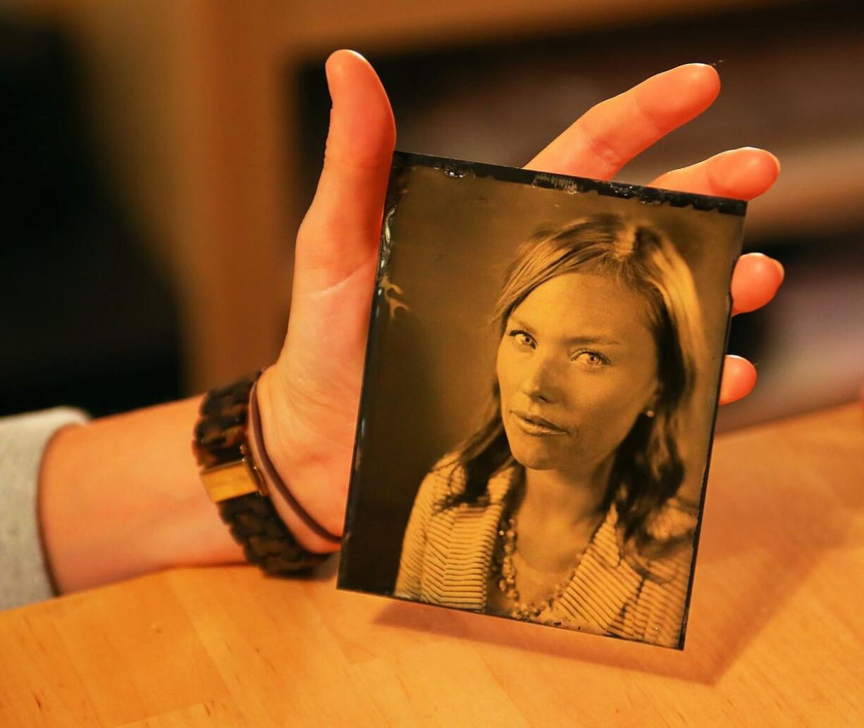 Allison Parker looks at one of the tintype portraits of her done by Josiah Morgan at his studio in Norcross, Ga.