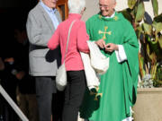 Pastor Ronald J. Rozniak greets parishioners at Our Lady of Mt. Carmel Catholic Church in Ridgewood, N.J., on Sunday.