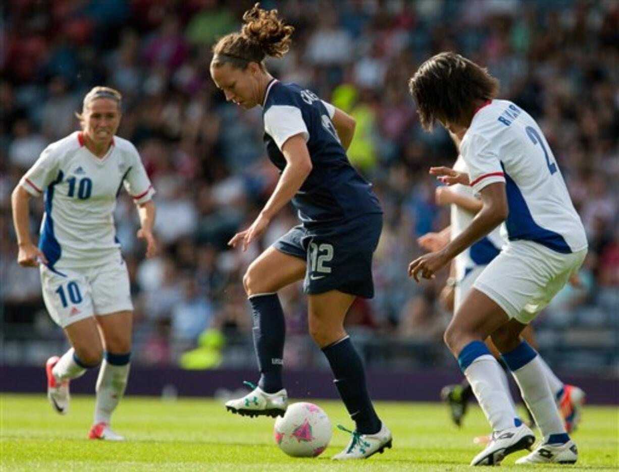 United States' Lauren Cheney, center, shields the ball from France's Wendie Renard, right, during the women's group G soccer match between the United States and France at the London 2012 Summer Olympics, Wednesday, July 25, 2012, at Hampden Park Stadium in Glasgow.