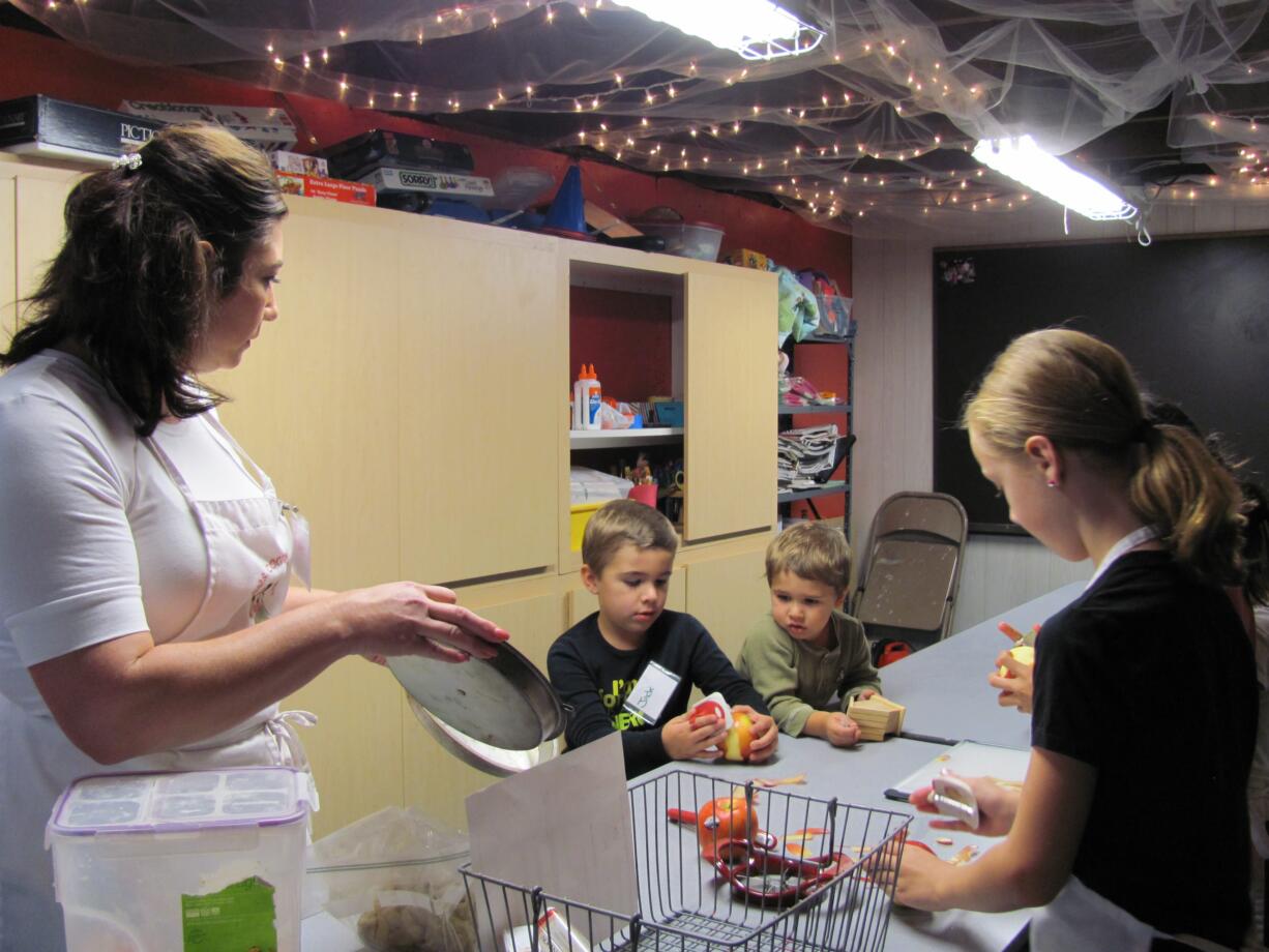 Danielle Frost/Post-Record
Heidi O'Connor, executive director of The Kids Cooking Corner, instructs her students on how to safely peel an apple. The group made pie, festive salad, and a cheesy butternut squash casserole.