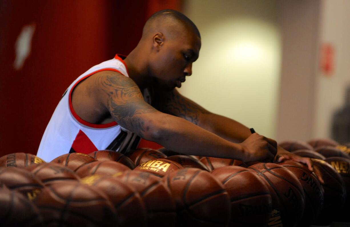 Portland Trail Blazers' Damian Lillard signs basketballs during the team's NBA basketball media day in Portland, on Monday.