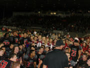 In a post-game huddle, the Camas Papermakers celebrate their 42-17 win against Skyview Friday night. It was the Papermakers' first league game following its move to the GSHL's Class 4A -- the largest classification in the state. Read the Tuesday, Oct.