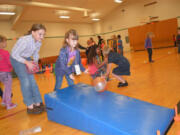 Cape Horn-Skye Elementary student Haleigh Byrd (left) helps Allison Drake during the recent Sport-a-Thon.