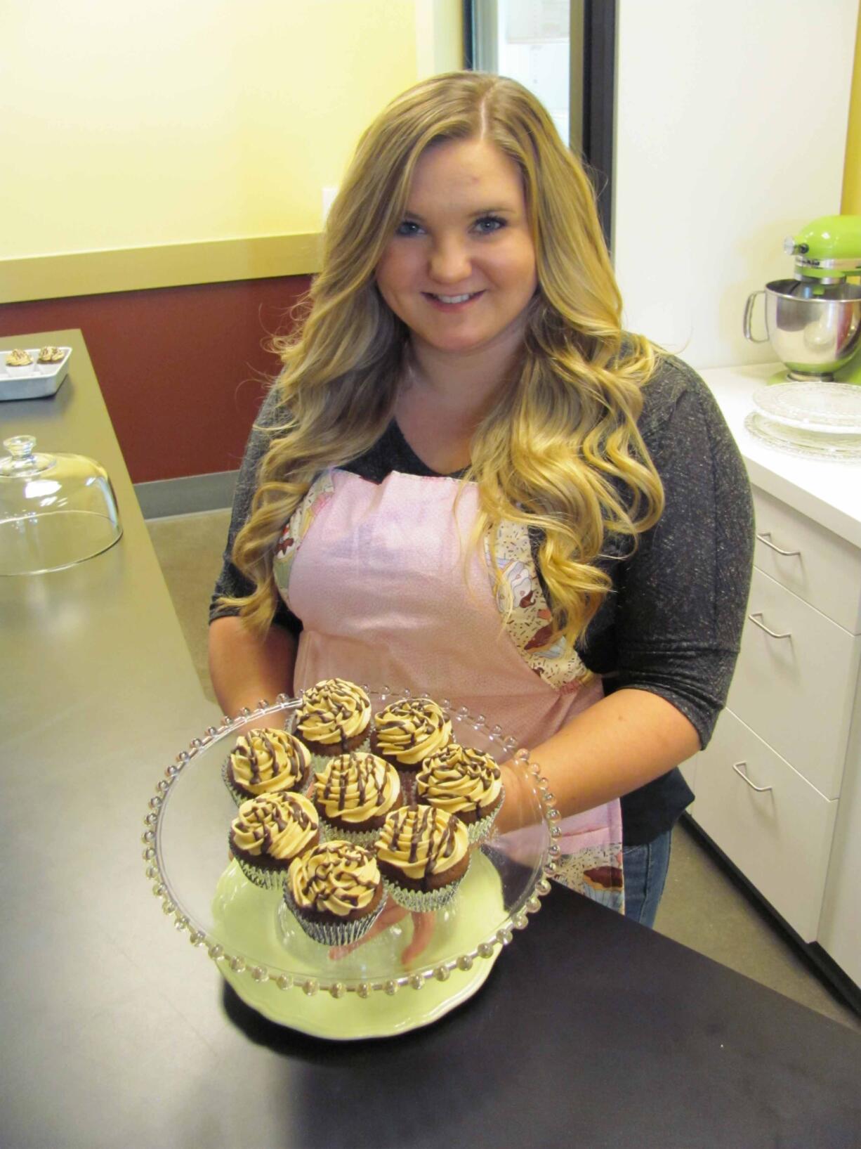 Bethani Higdon shows examples of chocolate cupcakes at the future site of WildFlour Cafe &amp; Cupcakes. &quot;It's all from scratch,&quot; she said. &quot;Nothing is from a box.&quot; Bethani and her mother, Connie, plan to open the cafe in Washougal Town Square this Friday. &quot;She loves to bake and cook,&quot; Connie said.