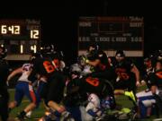 Offensive linemen for Washougal push Ridgefield off the goal line while Bobby Jacobs jumps over the pile to score one of his four touchdowns Friday, at Fishback Stadium.