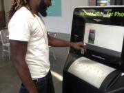 Marcellus Lang, a security guard at Old Sacramento sports bar, uses an EcoATM kiosk at Downtown Plaza mall to get instant cash for two devices: a used cellphone and an iPod Touch.