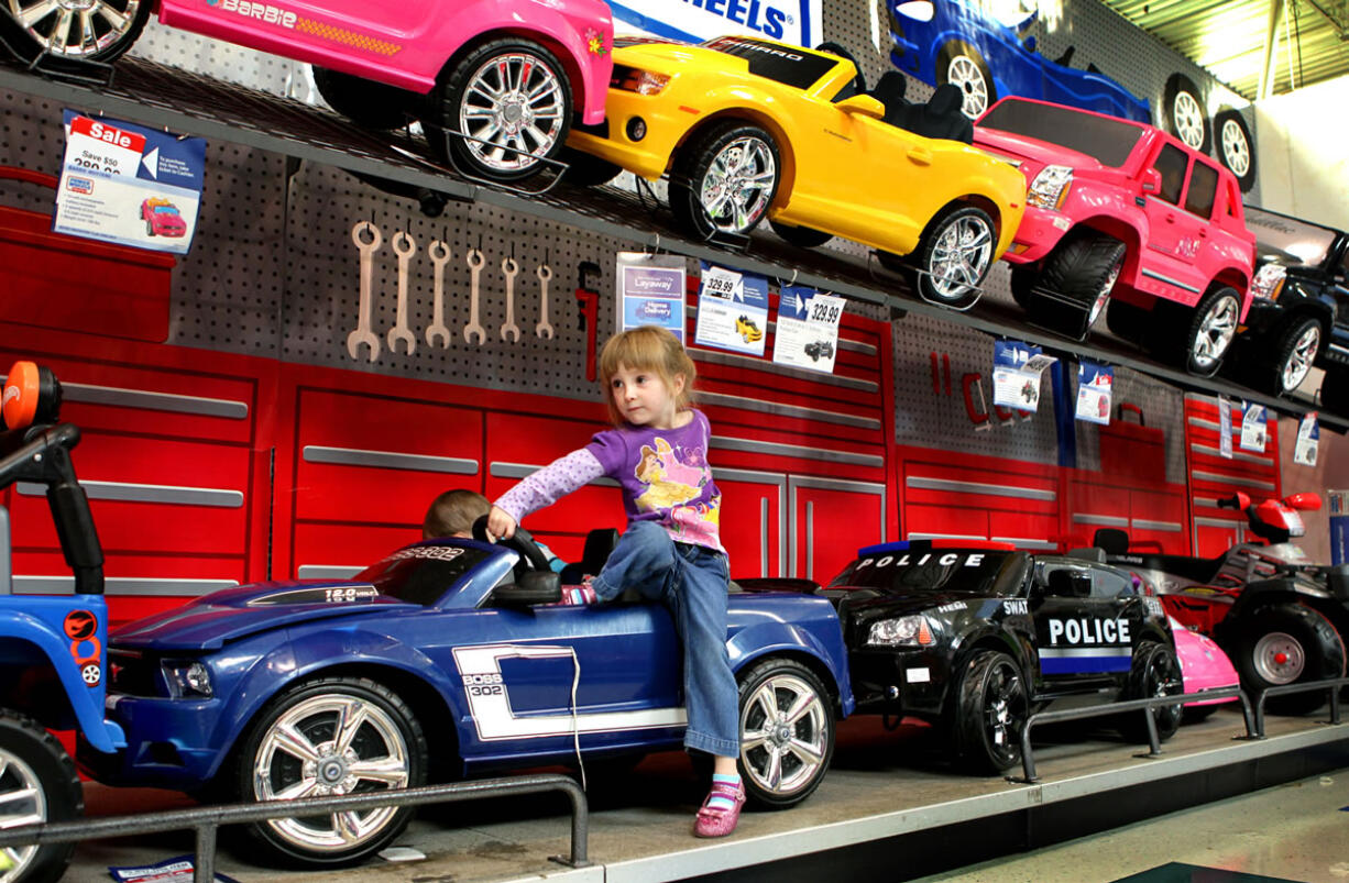 Ava Dalessandro, 3, of Arnold,Mo., tries out the cars Oct. 11 while shopping with her family at Toys R Us in Sunset Hills, Mo. Many retailers are offering holiday shoppers layaway again this year, but Ava's mother, Kayce, won't be taking advantage of the offer.