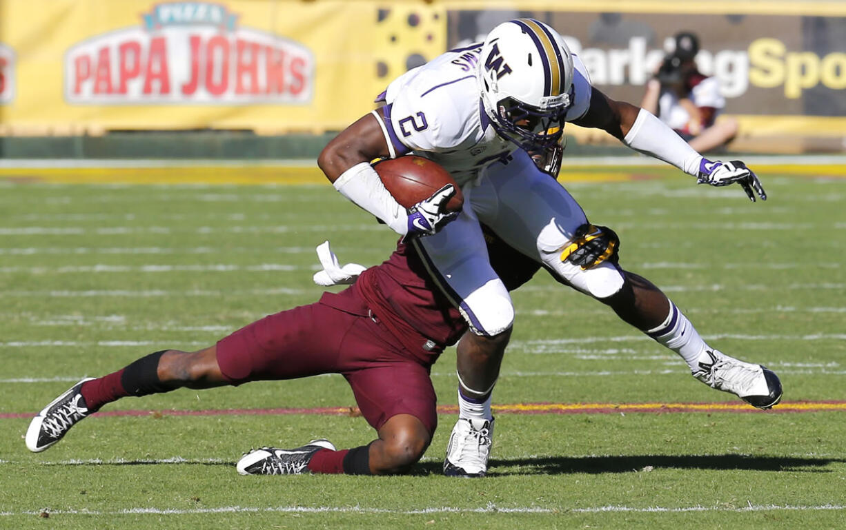 Washington wide receiver Kasen Williams (2) is tackled by Arizona State defensive back Robert Nelson during the first half of an NCAA college football game, Saturday, Oct. 19, 2013, in Tempe, Ariz.