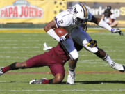 Washington wide receiver Kasen Williams (2) is tackled by Arizona State defensive back Robert Nelson during the first half of an NCAA college football game, Saturday, Oct. 19, 2013, in Tempe, Ariz.