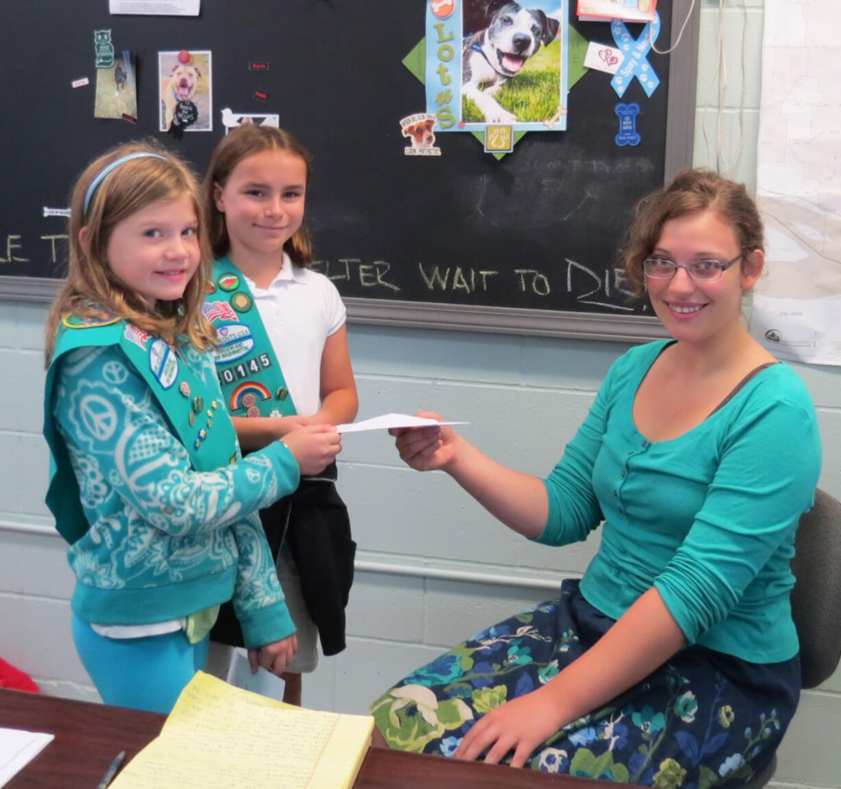 Kendra Short and Syerrah Wilson-Brown (left to right) present a money order to West Columbia Gorge Humane Society volunteer Caitlin Hanky.