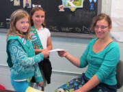 Kendra Short and Syerrah Wilson-Brown (left to right) present a money order to West Columbia Gorge Humane Society volunteer Caitlin Hanky.