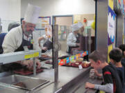 Washougal Mayor Sean Guard serves lunch to children at Gause Elementary School in celebration of National School Lunch Week.