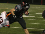 Nate Beasley bowls over a Battle Ground Tiger Friday, at Doc Harris Stadium. The Camas High School junior had two touchdown runs and an interception on defense.