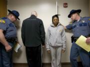 Washington State Patrol Trooper Bennie Taylor, left, weighs Tyson Bellikka as Juliann Bernerdi is measured by Trooper Will Finn, right, before starting a physical fitness test.