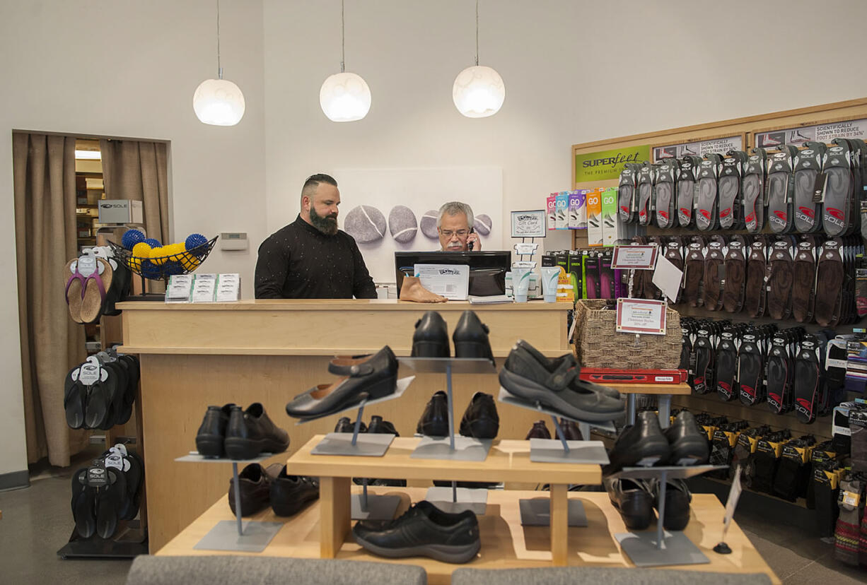 Ryan Downey, left, works behind the front counter with Jeff Horowitz on Tuesday morning at When the Shoe Fits in Southeast Vancouver.