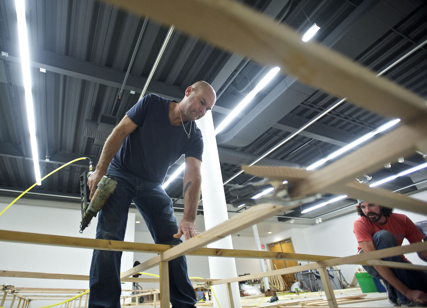 Artist Mike Rathbun sets up his installation last week at Clark College's Archer Gallery, with help from assistant Jakob Swan.