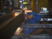 A worker uses a grinder inside Thompson Metal Fab, one of three Vancouver manufacturers that said the proposed bridge's lower height would have had a negative impact on their businesses.