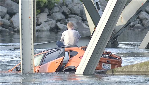 An unidentified man waits on his submerged vehicle in the Skagit River Thursday May 23, 2012.