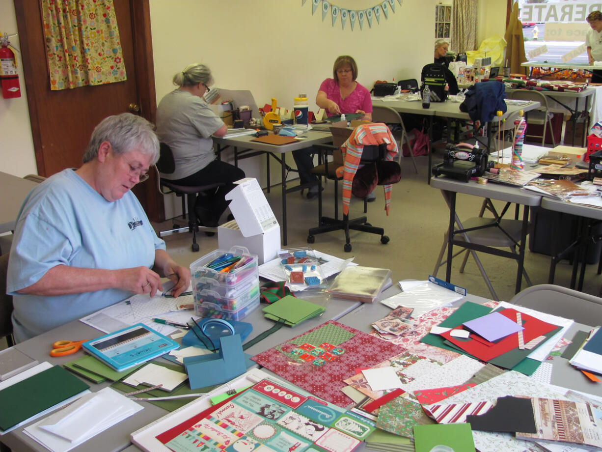 Julia Schlaht (lower left), of Vancouver, made Christmas cards Sunday, in Washougal, at Sew Desperate -- a new venture started by Anna Davis.