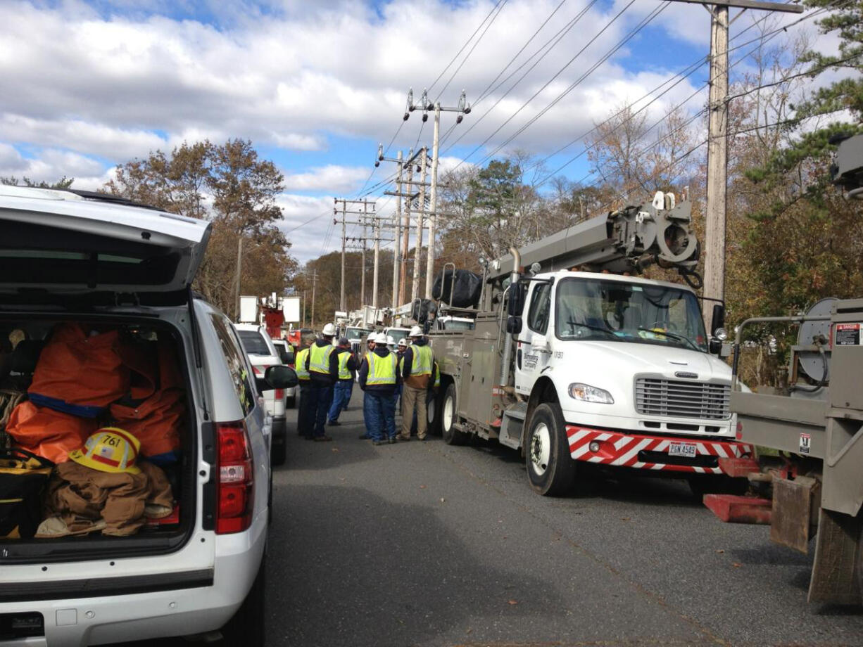 Line workers from Clark Public Utilities huddle on Saturday, Nov.