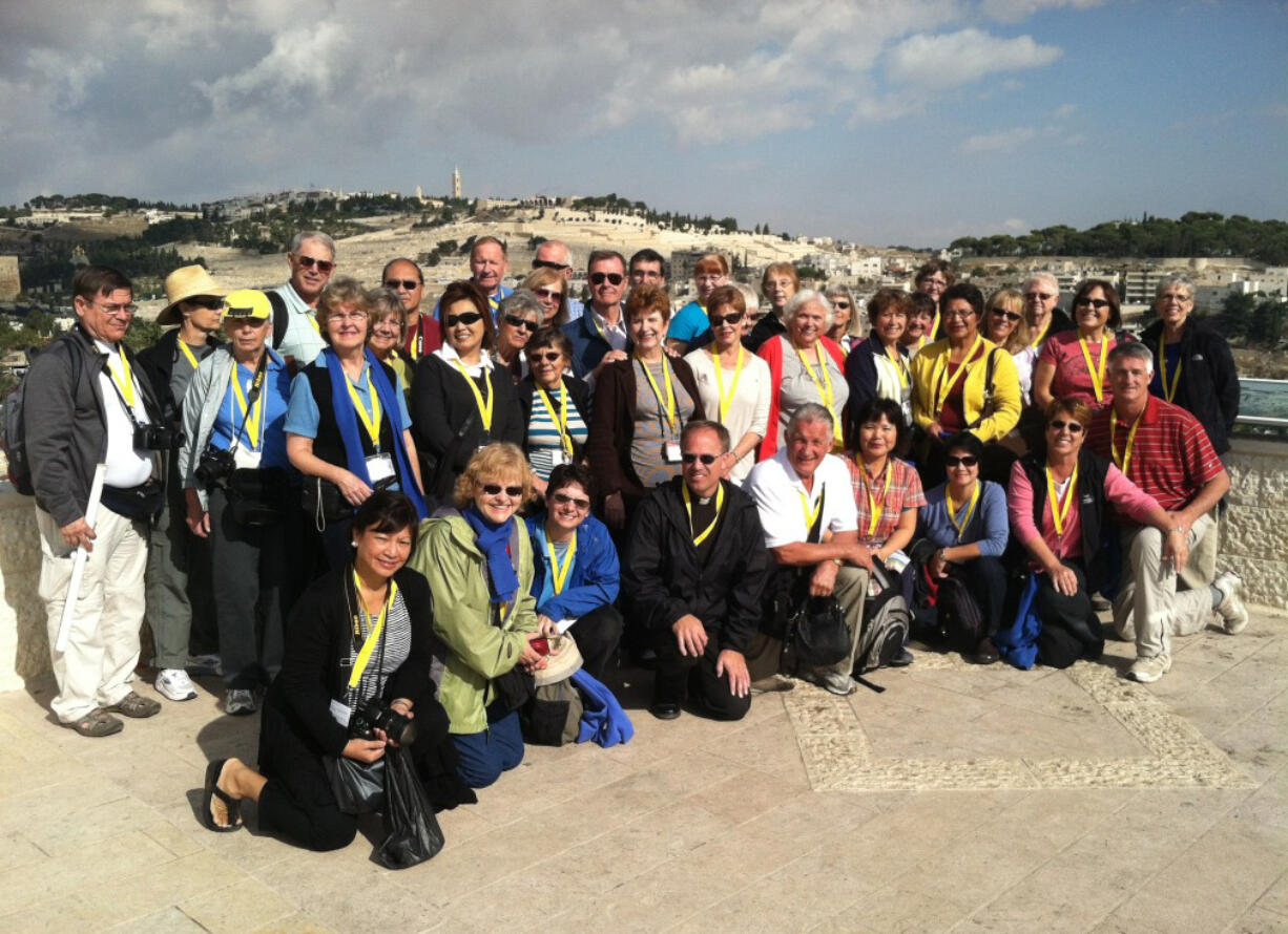 This picture of parishioners from Our Lady of Lourdes Catholic Church was taken before hostilities broke out. The group was in Jerusalem just finishing up a 12-day tour of Israel; that's the Mount of Olives behind them. Front row middle is Rev. Michael Radermacher, and Sue McDonald is far right in black vest and salmon shirt.