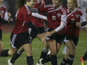 Camas High School's Teylen Sheesley, left, celebrates scoring a goal against Issaquah High School with teammates Rachel Gibson, center, and Makaela Norrish during a playoff game at Sparks Stadium in Puyallup Wash., Friday Nov. 16, 2012.