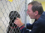 Mark Arlt, a volunteer at the West Columbia Gorge Humane Society, comforts an anxious dog.