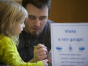 Erich Miller, 28, of Vancouver, helps his daughter Anaya, 4, make a rain gauge out of an empty water bottle at the Water Resources Education Center during an event to help children &quot;explore winter.&quot;