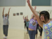 Kayla Banos-Arceo, 10, a student at Washington Elementary School, moves in a modern dance class led by Vancouver School of Arts and Academics teacher Fern Tresvan, background left.