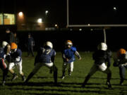 The Vancouver Bulldogs Pop Warner football team practices at Union High School by spotlight on Wednesday.