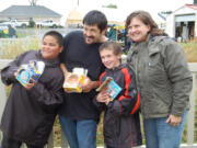 Hazel Dell: Champion pie eaters Edrianne Layog, 11; Johny Decoteau, 35; and Quentin Decoteau, 8, are congratulated by Susan Tissot, executive director of the Clark County Historical Museum during Harvest Fun Day.