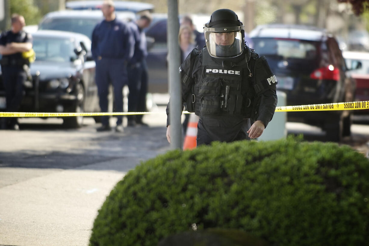 Jeff Olson with the Vancouver Police Department investigates an area outside The Columbian office on Tuesday after a suspicious container was found.