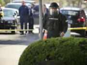 Jeff Olson with the Vancouver Police Department investigates an area outside The Columbian office on Tuesday after a suspicious container was found.